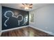 Bedroom featuring hardwood floors, a ceiling fan, and a mural on the wall at 556 Westwood Dr, Kannapolis, NC 28081