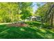 A single-story home that is surrounded by green landscaping and many trees at 556 Westwood Dr, Kannapolis, NC 28081