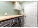 Laundry room features modern washer and dryer with butcher block folding table at 585 Highland Ridge Rd, Mooresville, NC 28115