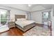 Spacious primary bedroom with tray ceilings, wood floors, large bed, and patterned rug at 585 Highland Ridge Rd, Mooresville, NC 28115