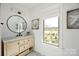Charming bathroom with wicker vanity, marble countertop, round mirror and natural light at 5888 Wood Duck Way, Catawba, NC 28609