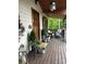 Inviting front porch featuring a wooden door, decor, and ample seating amidst a wooded backdrop at 5888 Wood Duck Way, Catawba, NC 28609