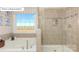 A luxurious bathroom showcases a tub, tiled shower, and natural light from the window at 7027 Butternut Oak Ter, Huntersville, NC 28078