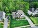 Overhead view of a two-story home with a well-kept lawn, driveway, and mature trees at 7935 Harrington Woods Rd, Charlotte, NC 28269