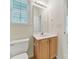 Bright bathroom featuring a wooden vanity, neutral walls, and a window with natural light at 7935 Harrington Woods Rd, Charlotte, NC 28269