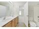 Bright bathroom with double sink vanity and open door to carpeted bedroom with natural light at 7935 Harrington Woods Rd, Charlotte, NC 28269