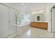 Bright bathroom featuring dual sinks, glass shower, soaking tub and natural lighting at 7935 Harrington Woods Rd, Charlotte, NC 28269