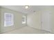 Carpeted bedroom featuring two windows that provide natural light and a white door at 7935 Harrington Woods Rd, Charlotte, NC 28269