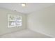 Neutral bedroom with carpet, a ceiling light, and a window with green trees outside at 7935 Harrington Woods Rd, Charlotte, NC 28269