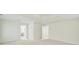Bright room featuring neutral carpet, light walls, and doorways to an en-suite bathroom and closet at 7935 Harrington Woods Rd, Charlotte, NC 28269