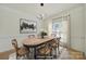 Sunlit dining area showcasing a rustic wooden table, unique chandelier, and stylish window treatments at 7935 Harrington Woods Rd, Charlotte, NC 28269