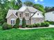 Beautiful brick front exterior of home featuring lush landscaping and a well-manicured lawn at 7935 Harrington Woods Rd, Charlotte, NC 28269