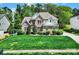 Charming two-story home with a green lawn, manicured shrubs, and a brick facade at 7935 Harrington Woods Rd, Charlotte, NC 28269