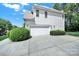Attached garage with manicured landscaping and a paved driveway at 7935 Harrington Woods Rd, Charlotte, NC 28269