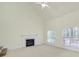 Bright living room featuring a fireplace, ceiling fan, and large windows overlooking backyard at 7935 Harrington Woods Rd, Charlotte, NC 28269