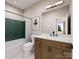 Modern bathroom features green tiled accent wall, wood vanity, and sleek black hardware at 8048 Cedarsmith Ct, Charlotte, NC 28217