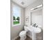 Contemporary powder room featuring a pedestal sink, modern fixtures, and natural light at 8048 Cedarsmith Ct, Charlotte, NC 28217