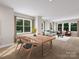 Open concept dining area with wood table set and views to living spaces and outdoors at 8048 Cedarsmith Ct, Charlotte, NC 28217