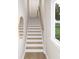 A well-lit staircase with white risers, wood treads, and a simple wood handrail at 8048 Cedarsmith Ct, Charlotte, NC 28217