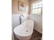 Freestanding bathtub with modern black fixtures set against white subway tile and wood look flooring at 8810 Cool Meadow Dr, Huntersville, NC 28078