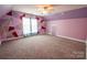 Bright bedroom featuring stylishly painted accent wall, neutral carpet, and ample natural light at 8810 Cool Meadow Dr, Huntersville, NC 28078