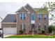 Traditional two-story brick home featuring a well-manicured lawn and attached two-car garage at 8810 Cool Meadow Dr, Huntersville, NC 28078