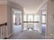 Open hallway featuring neutral color palette, carpeted floor, wood and iron railing, and views into adjacent rooms at 8810 Cool Meadow Dr, Huntersville, NC 28078