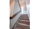 Carpeted staircase with wooden handrail leading to the upper level, featuring a window for natural light at 8810 Cool Meadow Dr, Huntersville, NC 28078
