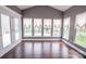 Bright sunroom with hardwood floors, multiple windows, and access to the outdoor deck at 8810 Cool Meadow Dr, Huntersville, NC 28078