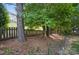 Enjoy shade and privacy in the backyard, featuring mature trees and a wood fence boundary at 9312 Seamill Rd, Charlotte, NC 28278