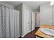 This half bathroom features a wood vanity, modern fixtures, and a gray shower curtain at 9312 Seamill Rd, Charlotte, NC 28278