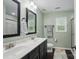 Bright bathroom features double sinks, black hardware and a standing shower at 9312 Seamill Rd, Charlotte, NC 28278