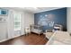 This bedroom features a custom mural, wood floors, and lots of natural light at 9312 Seamill Rd, Charlotte, NC 28278