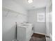 Well-lit laundry room featuring modern washer, dryer, and wire shelving for convenience at 9312 Seamill Rd, Charlotte, NC 28278