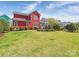 Spacious backyard featuring a well-kept lawn, landscaped garden beds, and colorful home at 9636 Cotton Stand Rd, Charlotte, NC 28277