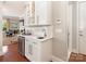 Modern bar area with white cabinetry, quartz countertop, wine cooler, and stainless steel hardware at 9636 Cotton Stand Rd, Charlotte, NC 28277