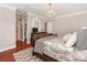 Bedroom features a dark wood sleigh bed frame, chandelier, walk-in closet, and hardwood flooring at 9636 Cotton Stand Rd, Charlotte, NC 28277