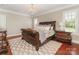 Elegant bedroom with a dark wood sleigh bed frame, chandelier and natural light from the windows at 9636 Cotton Stand Rd, Charlotte, NC 28277