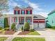 Charming two-story red home with a spacious front porch and well-manicured landscaping at 9636 Cotton Stand Rd, Charlotte, NC 28277