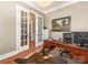 Well-lit office featuring a wooden desk, hardwood floors, and a decorative rug at 9636 Cotton Stand Rd, Charlotte, NC 28277