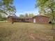 Brick house features a spacious backyard with mature trees and an inviting outdoor area with seating at 101 Stoneybrook Dr, York, SC 29745