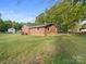 Lush backyard featuring a well-maintained lawn, mature trees, and a classic brick home at 101 Stoneybrook Dr, York, SC 29745