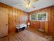Traditional bedroom featuring wood-paneled walls, hardwood floors, and double-hung windows at 101 Stoneybrook Dr, York, SC 29745
