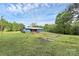 Blue home with a metal roof and cozy red front porch is set amidst a vast lawn at 1043 Sid Davis Rd, Chester, SC 29706
