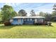 Blue home with a metal roof, a red porch and landscaped yard in a sunny outdoor setting at 1043 Sid Davis Rd, Chester, SC 29706