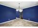 Dining room featuring tile flooring, blue accent walls, and a modern light fixture at 113 Hidden Creek Dr, Salisbury, NC 28147