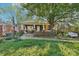 Charming brick home featuring a covered porch, a mature tree, and a well-maintained lawn at 115 E 11Th St, Salisbury, NC 28144
