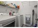 Efficient laundry room features modern washer and dryer, storage shelving, and space-saving design at 11839 Ridgeway Park Dr, Charlotte, NC 28277