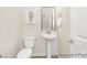 Modern half-bathroom featuring a pedestal sink and light neutral colors at 1303 Links Crossing Dr # 219, Monroe, NC 28112