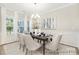 Elegant dining room with large windows, a chandelier, and a beautifully set table at 1303 Links Crossing Dr # 219, Monroe, NC 28112